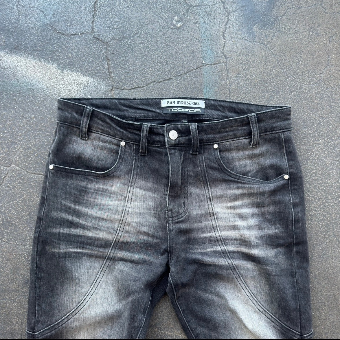 Grey jeans with a brand label on a textured gray surface