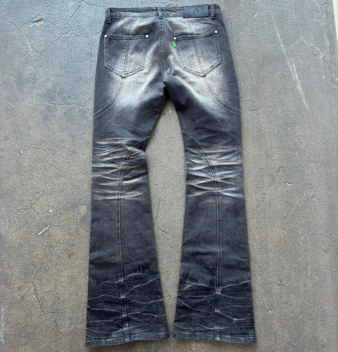 Black distressed jeans on a gray concrete floor